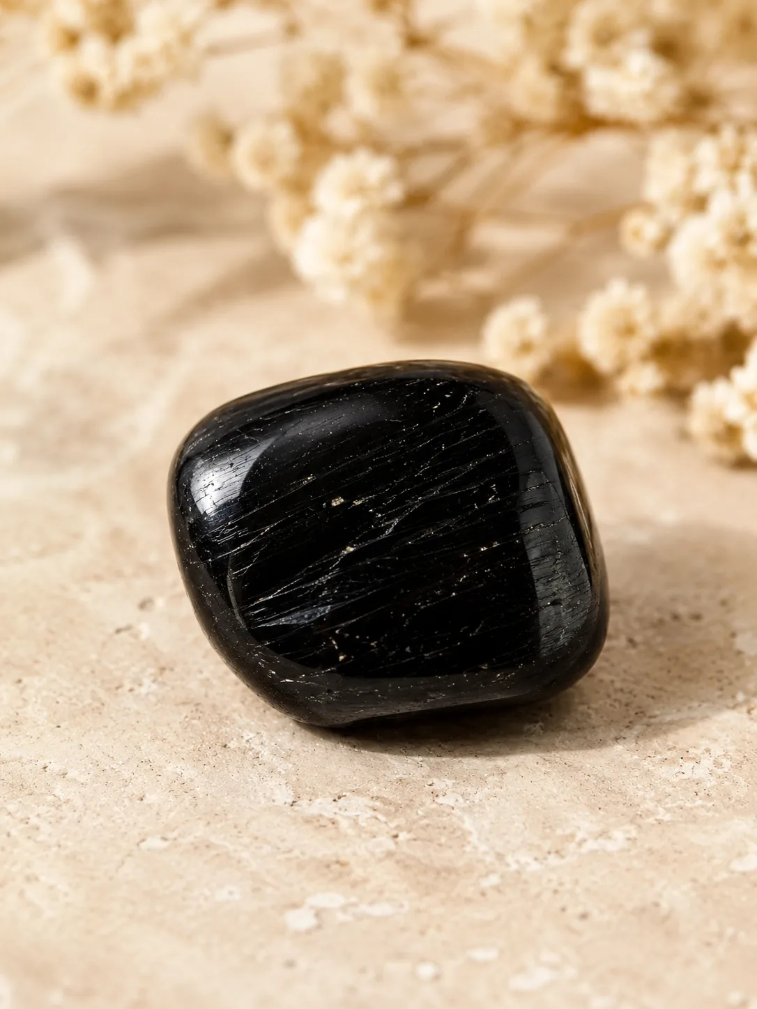 Close-up of polished black tourmaline tumble stone with natural crystal texture